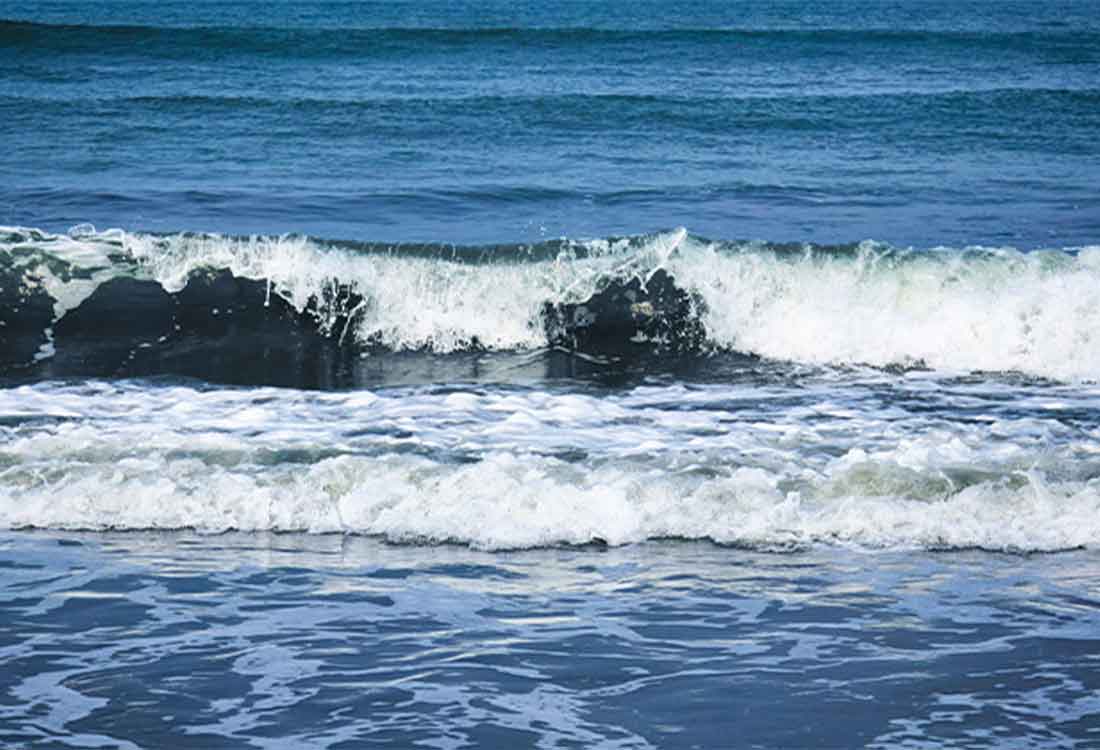 Blue ocean waves crashing onto shoreline